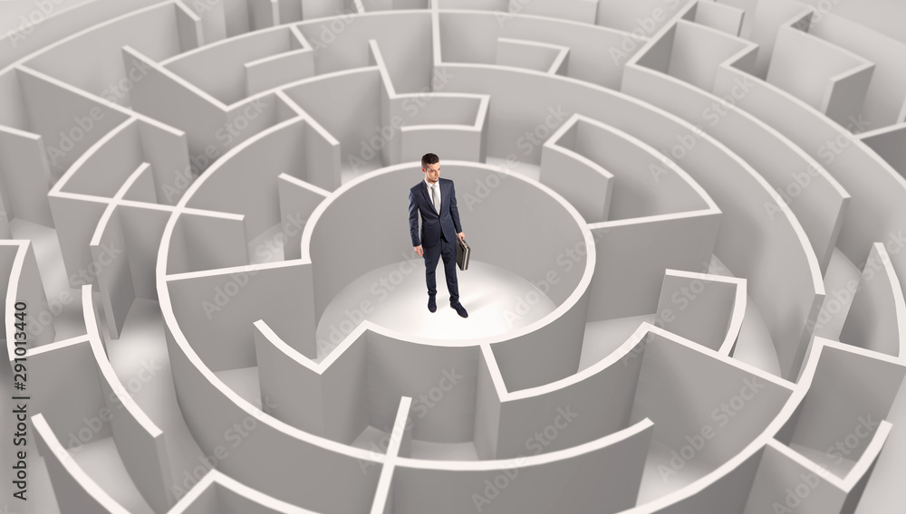 Young businessman standing in a middle of a 3d round maze Young businessman standing in a middle of a 3d round maze