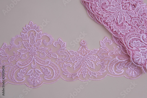 Texture lace fabric. lace on white background studio. thin fabric made of yarn or thread. a background image of ivory-colored lace cloth. Pink lace on beige background.