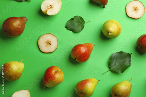 Ripe juicy pears on green background, flat lay