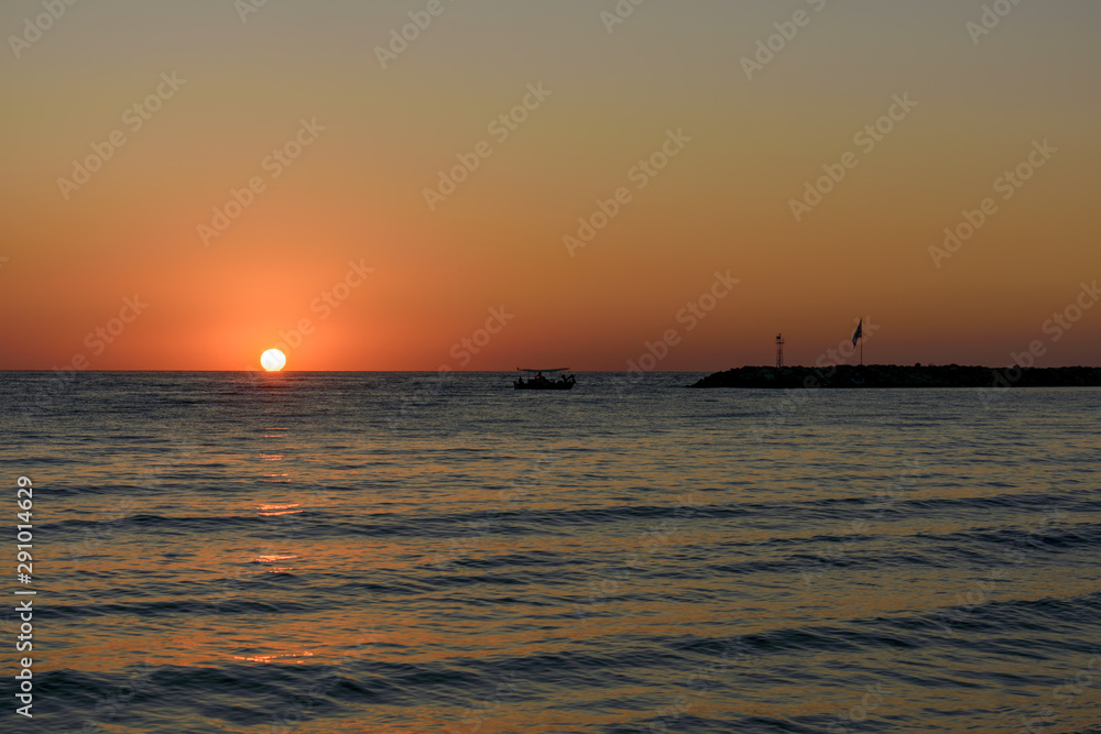 A fishing boat on the background of the morning sunset