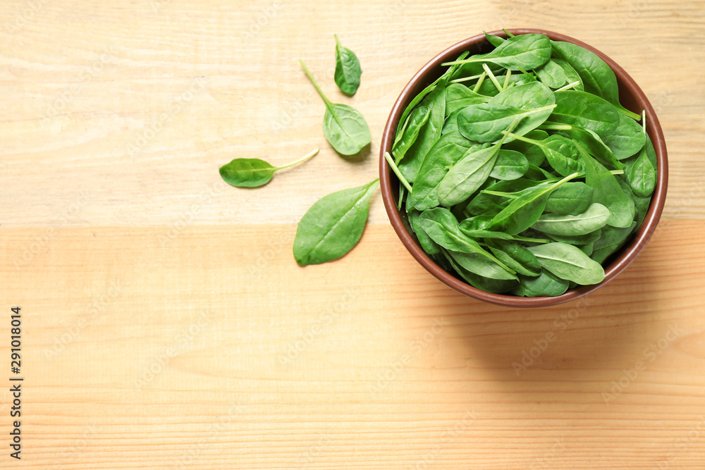 Fresh green healthy spinach on wooden table, flat lay. Space for text Fresh green healthy spinach on wooden table, flat lay. Space for text