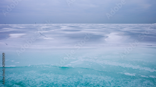Colorful frozen lake surface during a heavy overcast day
