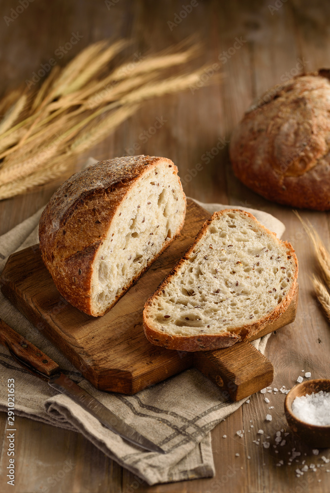 Homemade whole grain bread with flax seeds. Pieces of bread on a wooden board