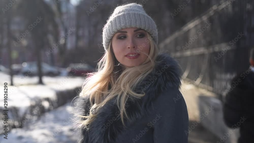 Portrait of beautiful blonde smiling young woman outside enjoying winter snow and sunny day looking at camera, smiling, walking Portrait of beautiful blonde smiling young woman outside enjoying winter snow and sunny day looking at camera, smiling, walking