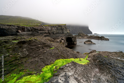 Mossy rocky shore surrounded by calm water photo