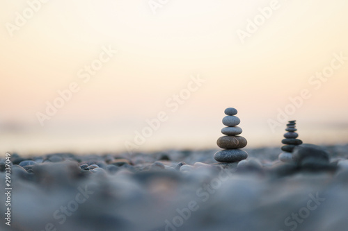 Balanced stone pyramid on pabbles beach with sunset. Zen rock  concept of balance and harmony.