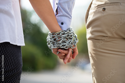 Couple's Hand Tied With Metal Chain photo