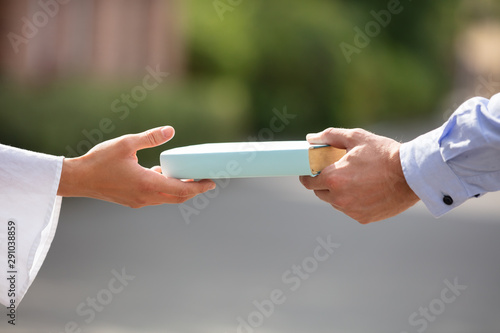 Man Giving Book To Woman