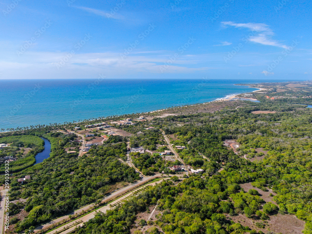 Obraz premium Aerial view of Praia Do Forte coastline town with blue ocean