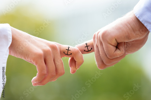 Close-up Of Couple Holding Index Fingers With Anchor Sign © Andrey Popov
