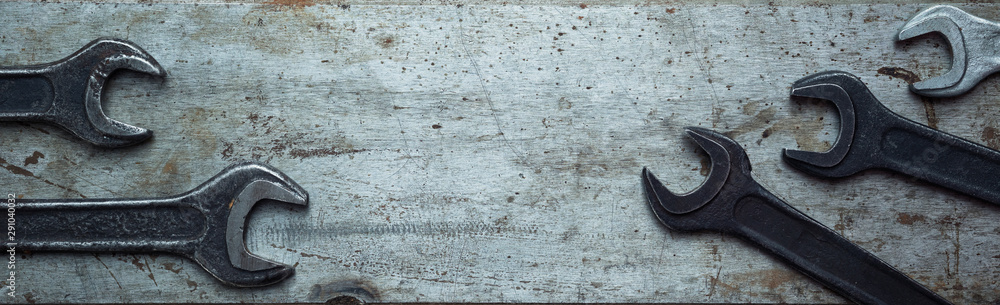 Wrenches laid out on a textured steel bench metal sheet. Top view with copy space. Industrial flat lay Wrenches laid out on a textured steel bench metal sheet. Top view with copy space. Industrial flat lay