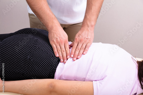 Physiotherapist Doing Female's Back Massage In Clinic photo