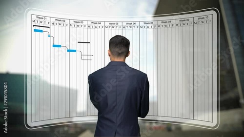 Businessman looks to Gantt chart, project schedule harmonogram work processes
