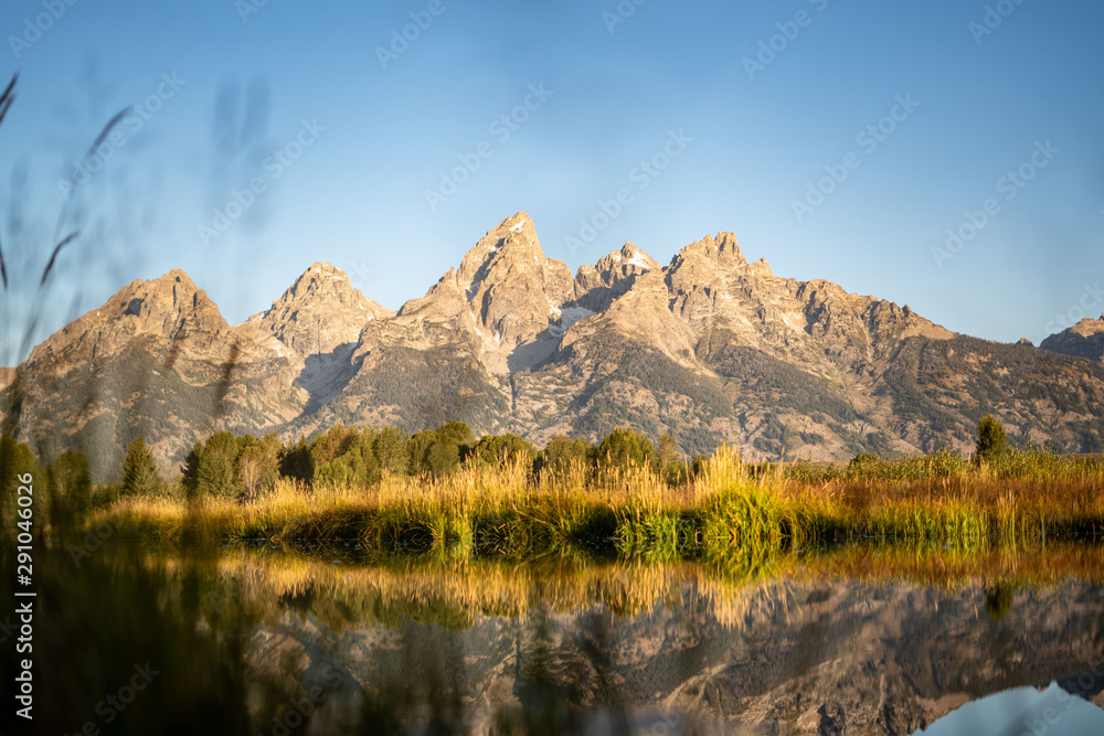 Rocky peaks of the Grand Tetons reflected in the river