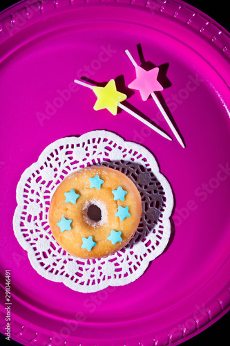 Top view on pink plate with birthday cake and candles photo