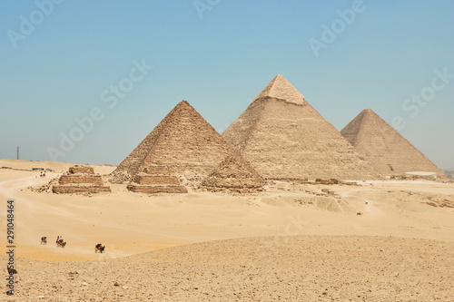 Tourists on camels are seeing Giza pyramids