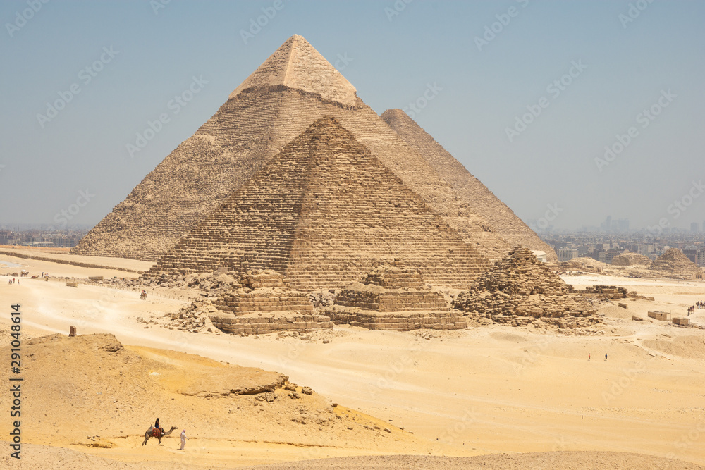 Tourists on camels are seeing Giza pyramids