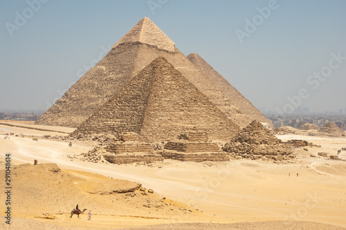 Tourists on camels are seeing Giza pyramids