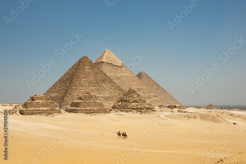 Tourists on camels are seeing Giza pyramids