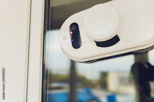 Vacuum cleaner robot cleaning window in high building outdoor. photo