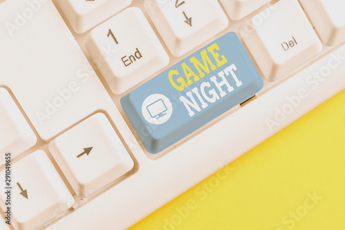 Text sign showing Game Night. Business photo showcasing event in which folks get together for the purpose of getting laid White pc keyboard with empty note paper above white background key copy space photo