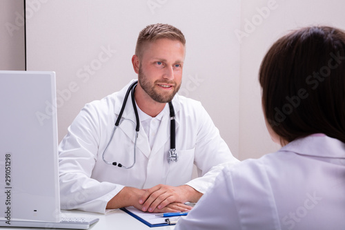 Happy Male Doctor And Nurse Having Meeting In Clinic