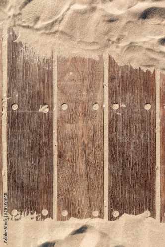 wooden texture of old wood and sand of a walkway on the beach