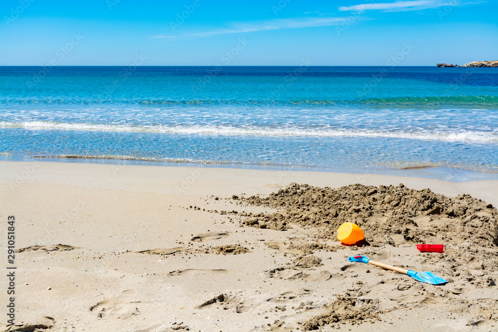 Crystal clear blue Mediterranean sea water on St.Croix Martigues beach and kids beach toys, Provence, France Crystal clear blue Mediterranean sea water on St.Croix Martigues beach and kids beach toys, Provence, France