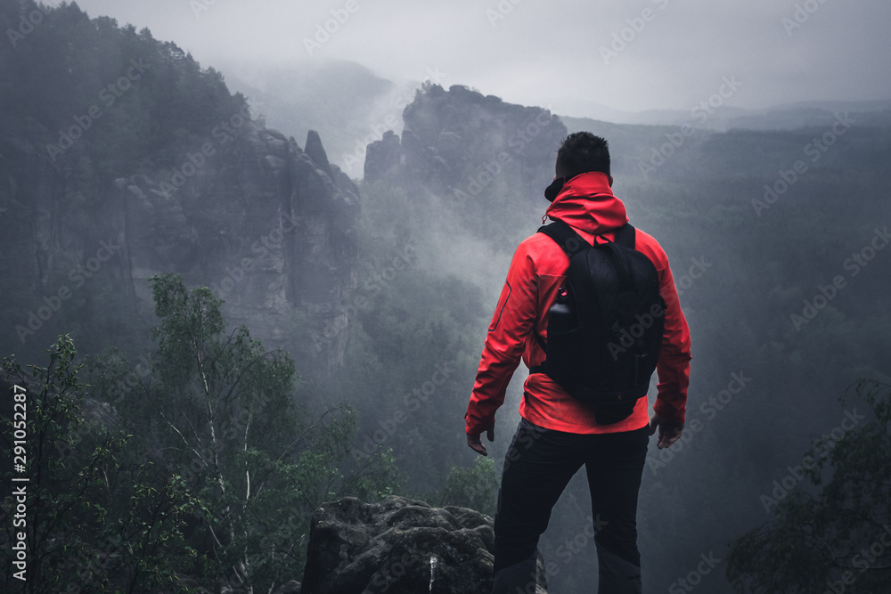 Wanderer auf dem Berg mit Ausblick im Nebel