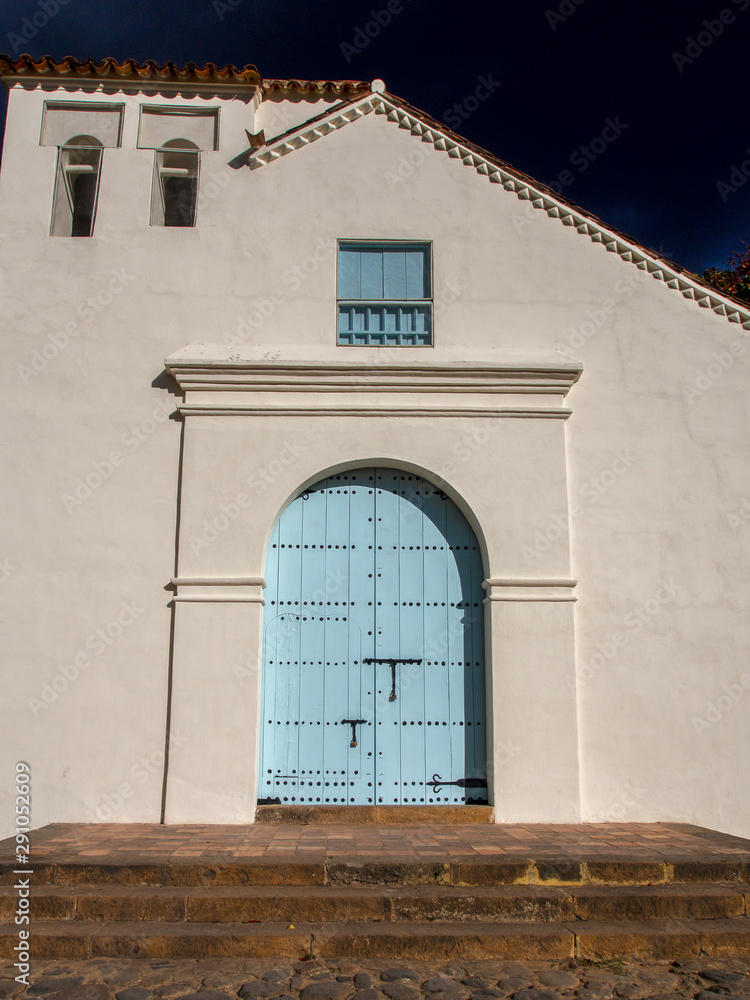 Facade of an old colonial church at the colonial town of Villa de Leyva, in the Andean mountains of central Colombia, at sunset.