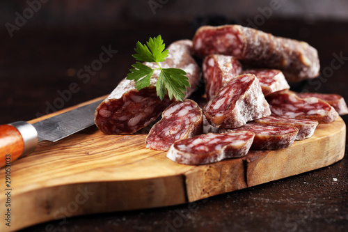 salami cut. thinly sliced salami on a wooden texture on the background.