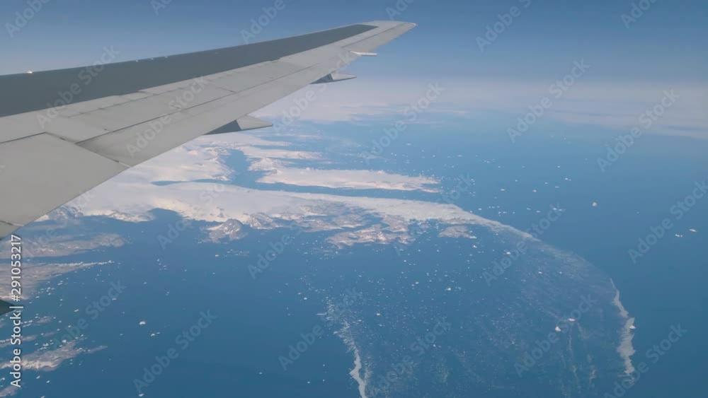 Aerial view of Greenland and the Atlantic Ocean from airplane widow. View from airplane flying over Greenland. Aerial view of Greenland and the Atlantic Ocean from airplane widow. View from airplane flying over Greenland.