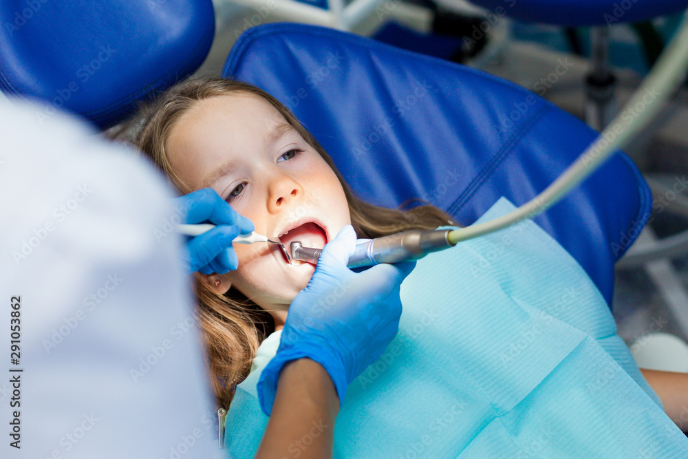 little girl sitting in the dentist chair. Children dentist examination