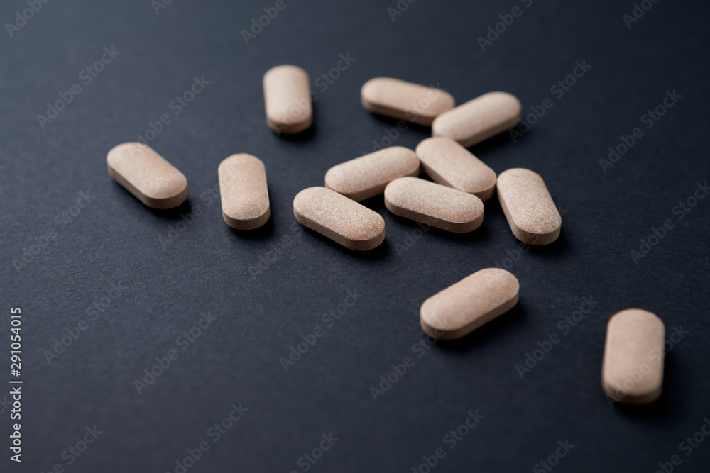 Rhodiola rosea. Golden root, rose root. Herbal pills with healthy medical plant on black background. Close up. 