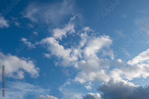 abstract background of light fluffy clouds on a bright blue sky