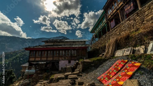 Timelapse of man moving around temple in village with moving clouds over it in Himachal. photo