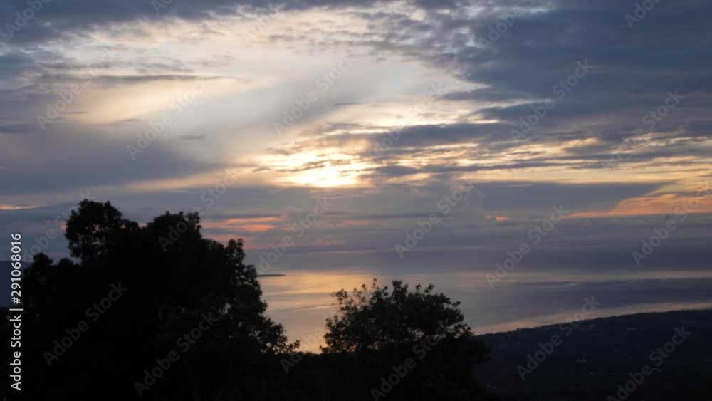 Timelapse of sunrise with colorful sky and clouds, ocean, trees and mountain. Timelapse of sunrise with colorful sky and clouds, ocean, trees and mountain.