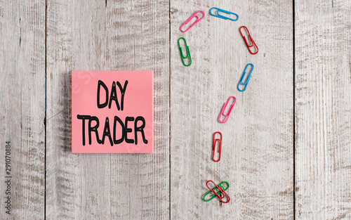 Writing note showing Day Trader. Business concept for A demonstrating that buy and sell financial instrument within the day Pastel colour note paper placed next to stationary above wooden table photo