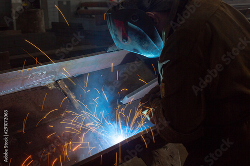 Worker at the factory welding closeup Industrial shot sparks