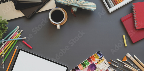 Overhead shot of artist work station with tablet, palette, painting tools and drawing equipment photo