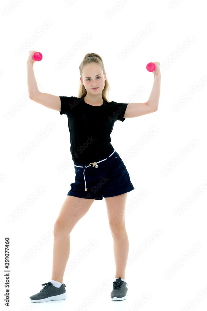 Little girl doing exercises with dumbbells.