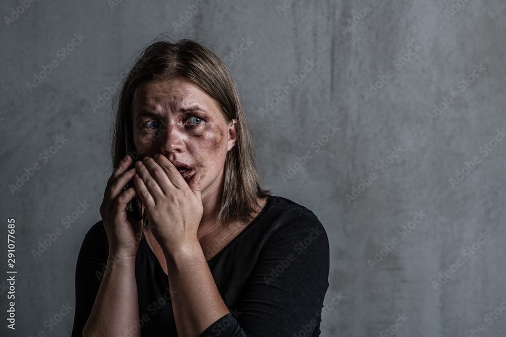 Woman victim of domestic violence and abuse asks for help by phone. Empty space for text Woman victim of domestic violence and abuse asks for help by phone. Empty space for text