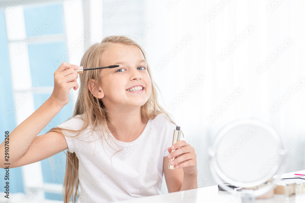 Little girl applies mascara on eyelashes at home Little girl applies mascara on eyelashes at home