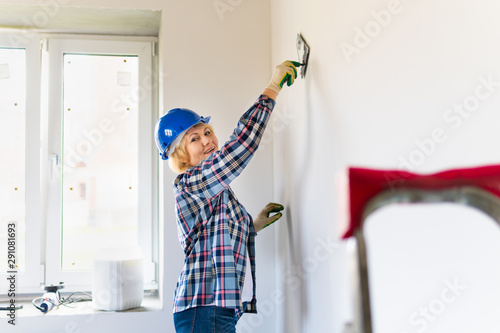 Woman Builder in the room making repairs.