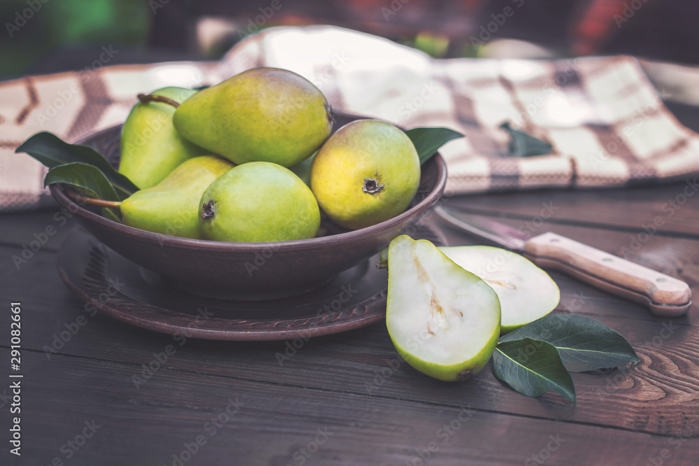 fresh pears and pear halves in a bowl on the table. background with fresh pears. harvest green pears closeup. fresh pears and pear halves in a bowl on the table. background with fresh pears. harvest green pears closeup.