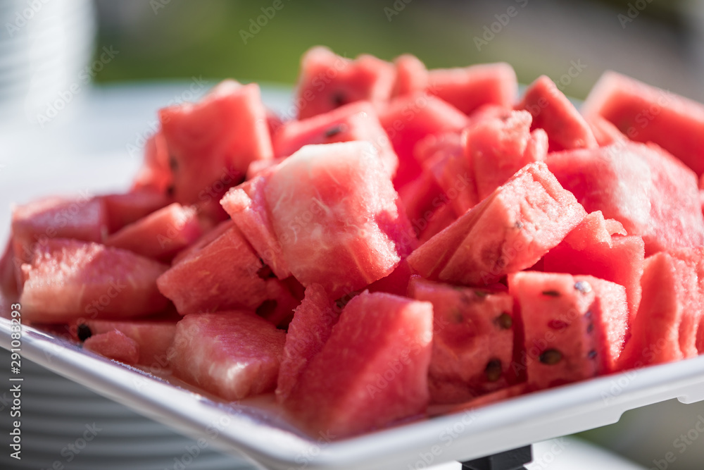 Close up of a tray of red and juicy watermelon slices against a bokeh background