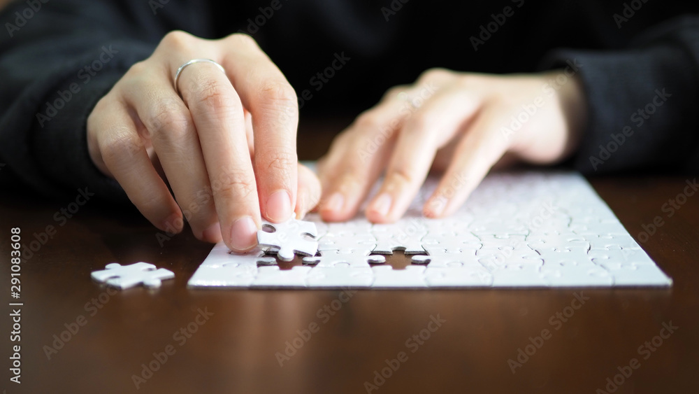 hand pick a piece of jigsaw to connect success on wooden table top selected focus hand pick a piece of jigsaw to connect success on wooden table top selected focus