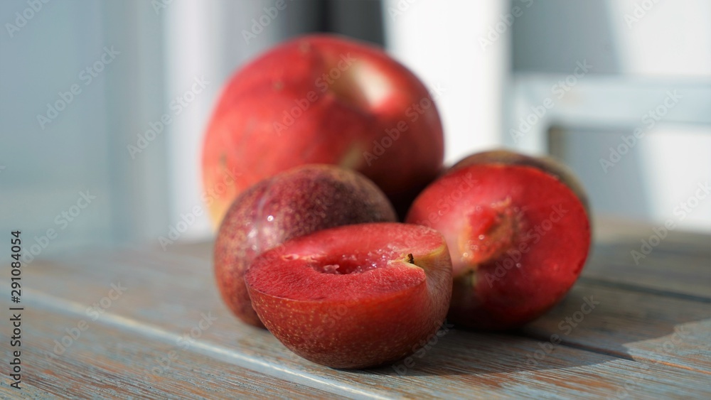 red plums and peaches on wooden surface red plums and peaches on wooden surface