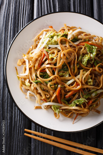 Delicious chinese stir fried from chow mein noodles with vegetables close-up on a plate. Vertical top view