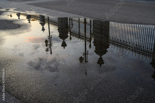 reflection of the Palacio Real, in Madrid on a puddle of water on the street